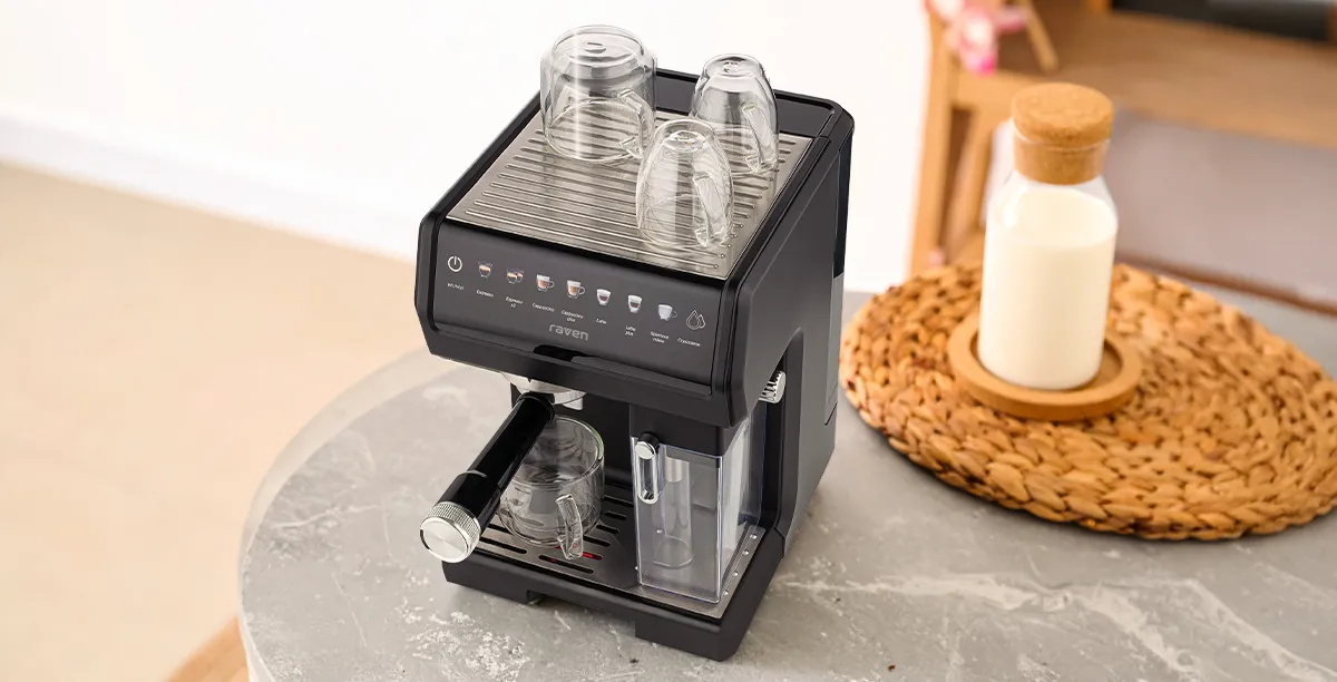 Кругла стільниця з кавоваркою EER007, трьома перевернутими склянками, плетеним килимком та пляшкою з-під молока поруч.