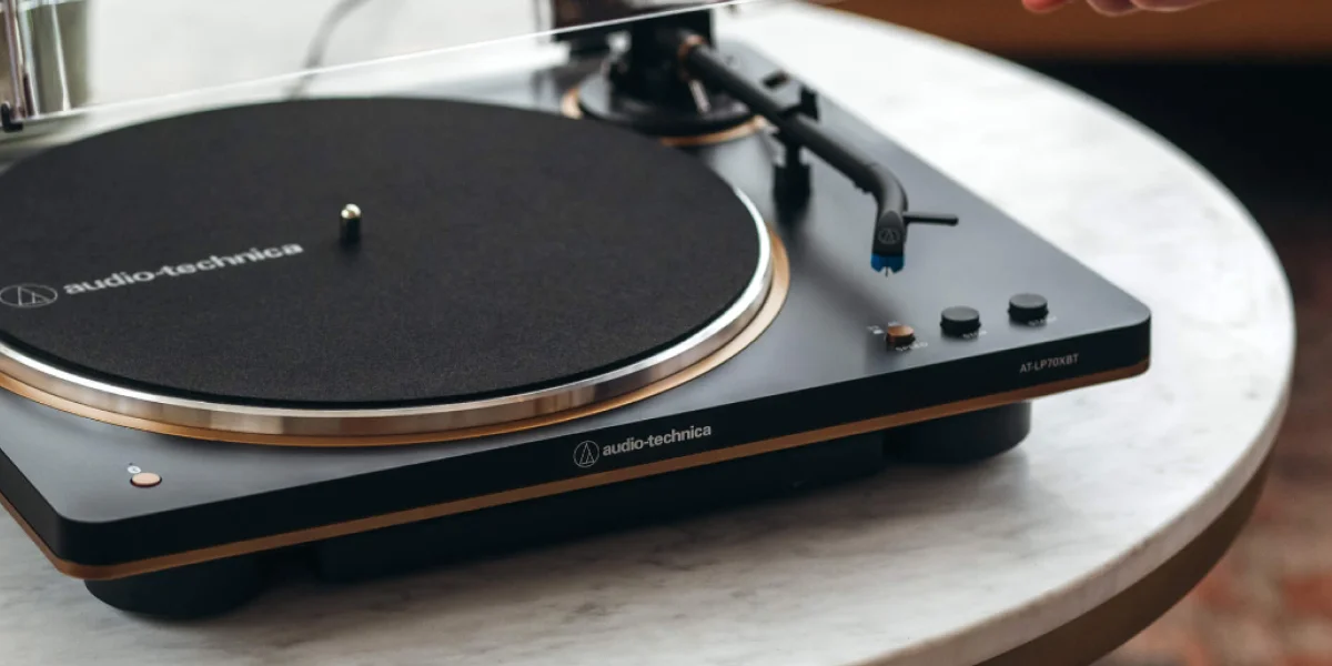 Програвач аудіопрогравача Audio-Technica AT-LP70XBT з тонармом, що стоїть на світлому мармуровому столі