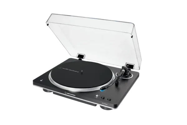 Чорний програвач аудіо Audio-Technica AT-LP70XBT з прозорою кришкою, розташований під кутом на білому тлі