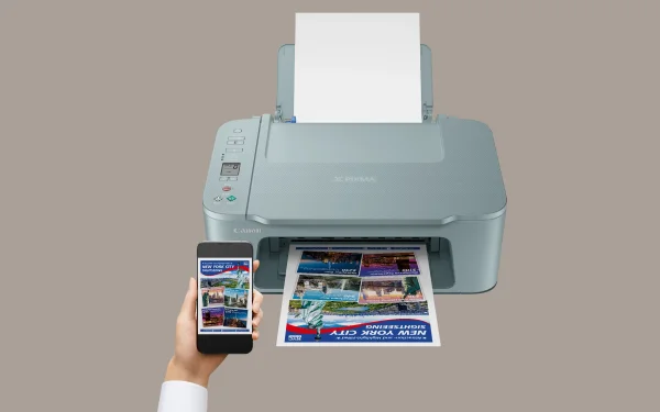Drukarka Canon drukująca zdjęcie z telefonu trzymanego przez użytkownika na tle szarego tła