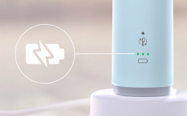 Нижня частина зубної щітки Philips Sonicare HX7406/02 на зарядному пристрої, поруч із нею знаходиться значок батареї та зелені індикатори.