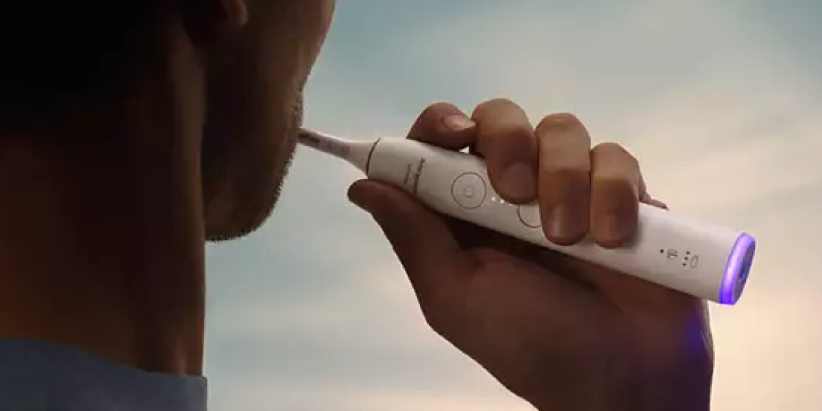 Чоловік чистить зуби зубною щіткою Philips Sonicare HX7400/01, знизу якої видно фіолетове сяйво.