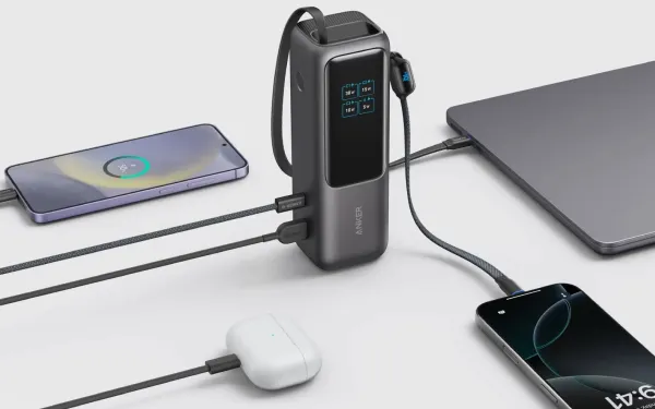 Зовнішній акумулятор Anker заряджає ноутбук, два телефони та навушники одночасно. Екран показує потужність зарядки.