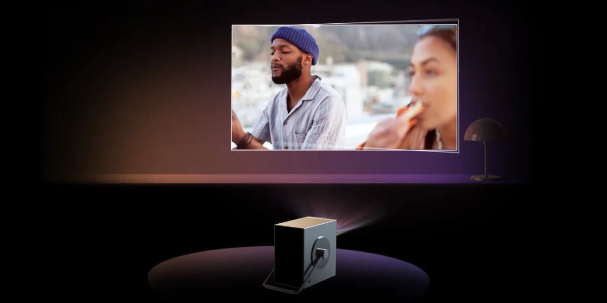 Проектор LG CineBeam Q демонструє фільм на великому екрані в темній кімнаті