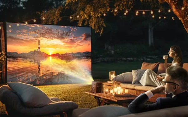 Кінопоказ просто неба за допомогою проектора LG CineBeam Q, що проектує зображення на великий екран у саду