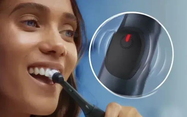 Жінка чистить зуби зубною щіткою Oral-B iO Series 2, поруч із якою крупним планом світиться червоний датчик тиску.