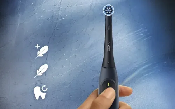 Рука тримає зубну щітку Oral-B iO Series 2, поруч із якою розташовані значки, що позначають режими чищення.