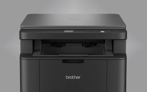 Чорний принтер Brother на сірому фоні, вигляд спереду, з лотком для паперу та панеллю керування зверху.