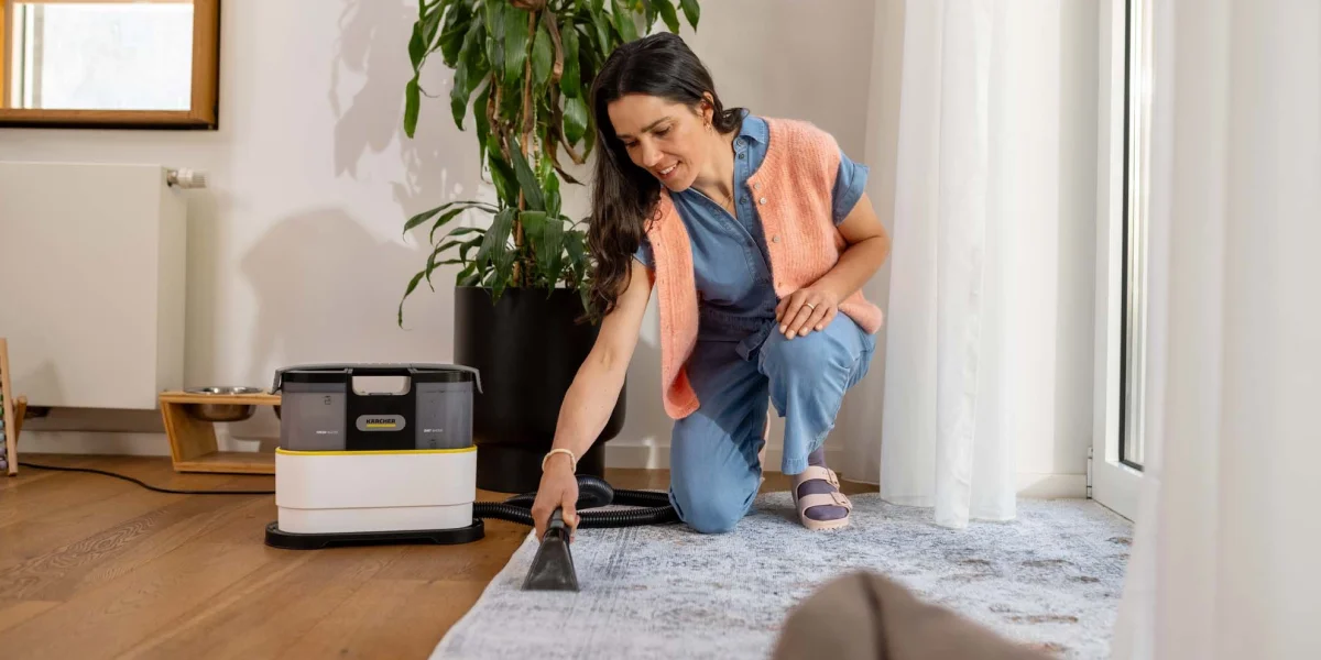 Людина чистить килим за допомогою насадки Karcher SE 2 Spot у вітальні