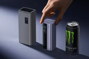 Зовнішній зарядний пристрій Baseus EnerGeek GR11 поруч із корпусом та банкою з напоєм, що показує розмір пристрою