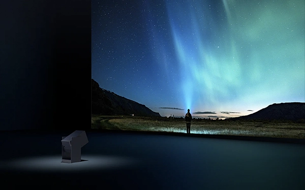 Проектор Wanbo Cube відображає на великому екрані нічний пейзаж з людиною, що стоїть під північним сяйвом.