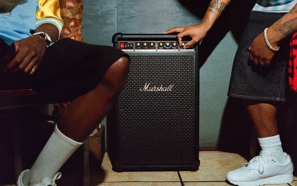 Гучномовець Marshall, розміщений між двома людьми, що сидять