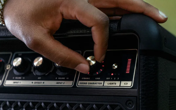 Крупний план руки, яка налаштовує диск режимів звуку.