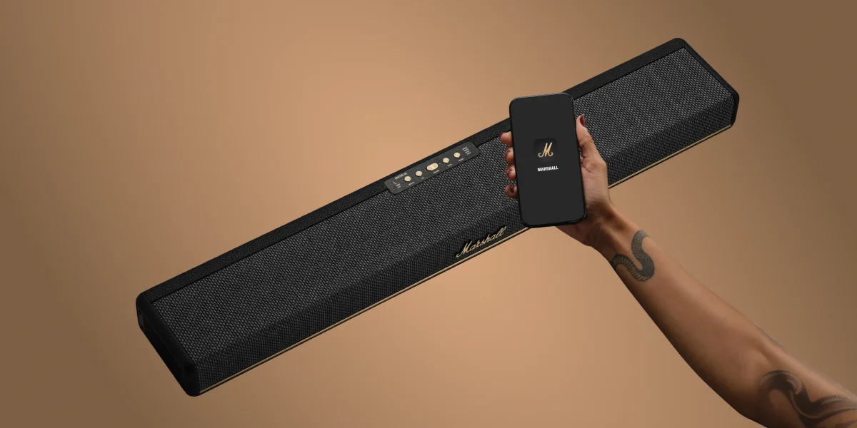 Саундбар Marshall та смартфон у руці, демонстрація підключення за допомогою застосунку